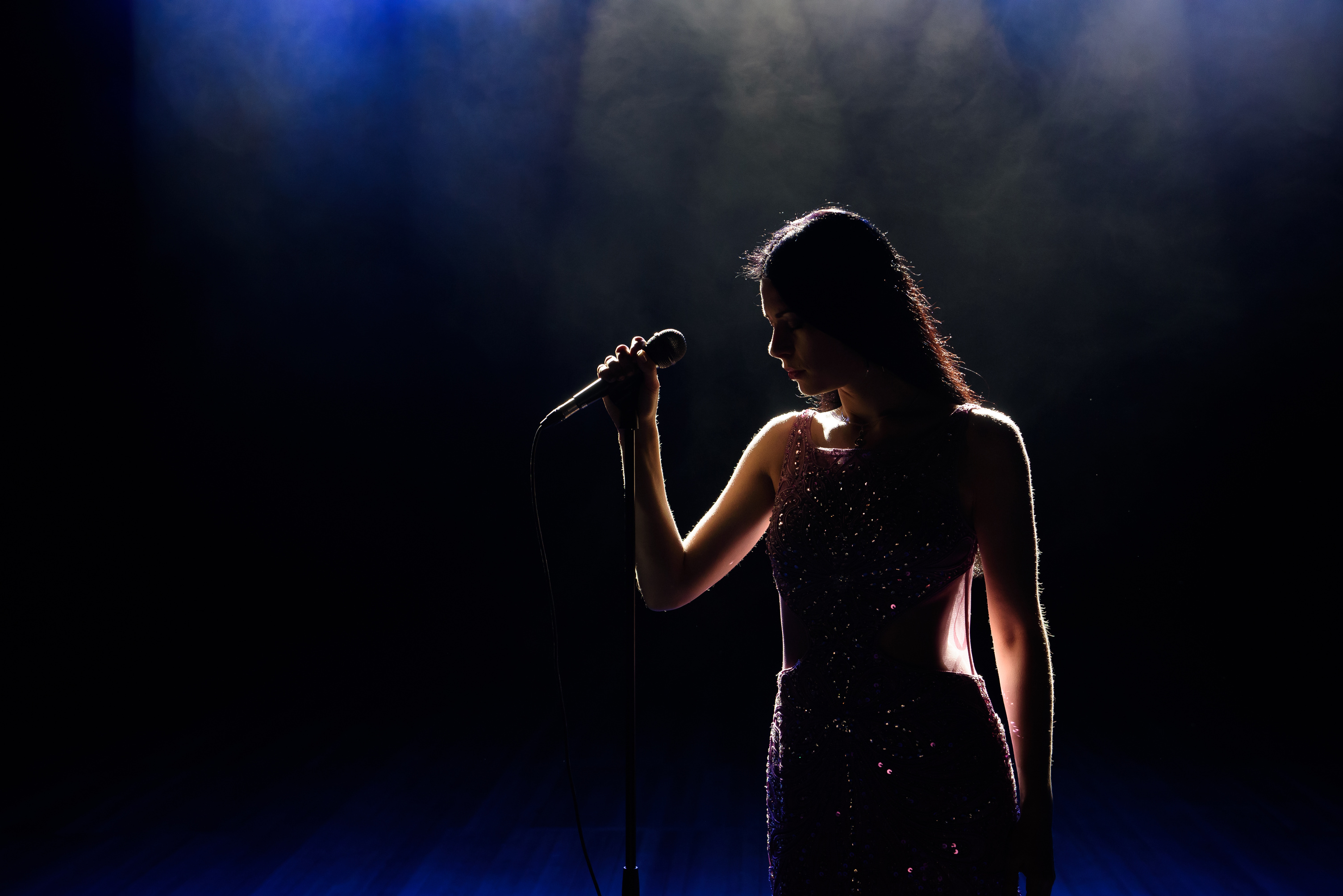 Singer woman on stage. Female singer on the stage holding a microphone.